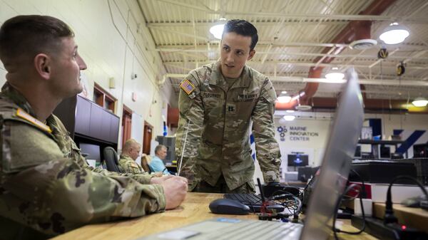 A founder of the Marne Innovation Center at Fort Stewart, U.S. Army Capt. Christopher Flournoy, center, talks with Staff Sgt. Michael Holloway while he works on the electromagnetic decoy that won the Army's innovative series Dragon's Lair competition in November. (AJC Photo/Stephen B. Morton)