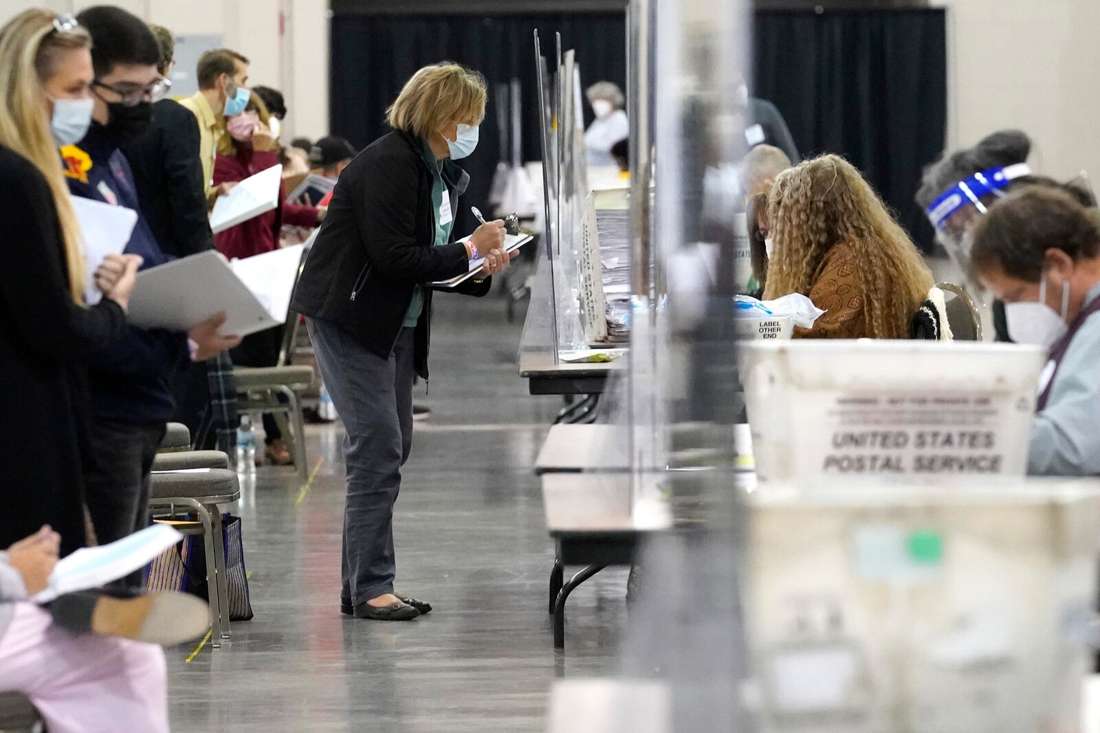 FILE - Recount observers watch ballots during a Milwaukee hand recount of Presidential votes at the Wisconsin Center, Nov. 20, 2020, in Milwaukee, Wis. (AP Photo/Nam Y. Huh, File)