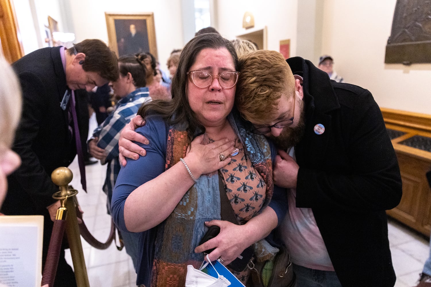 Christine Cox (center), a parent of a transgender teenager, becomes emotional after speaking to state Sen. Carden Summers, R-Cordele, (back left) outside the Senate at the Capitol in Atlanta on Monday, March 20, 2023. Activists appeared at the Capitol to protest SB 140, a bill sponsored by Summers that would prevent medical professionals from giving transgender children certain hormones or surgical treatment. (Arvin Temkar / arvin.temkar@ajc.com)