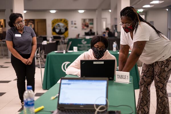 Diana Rowe (left) stays at a distance while helping Sarya Perez, accompanied by her mom Shiniqua Perez, register for classes at Georgia Gwinnett College on Monday afternoon, Aug. 3. Registration was being done by appointment, at a social distance and in an open location instead of in the normal office. BEN GRAY FOR THE ATLANTA JOURNAL-CONSTITUTION