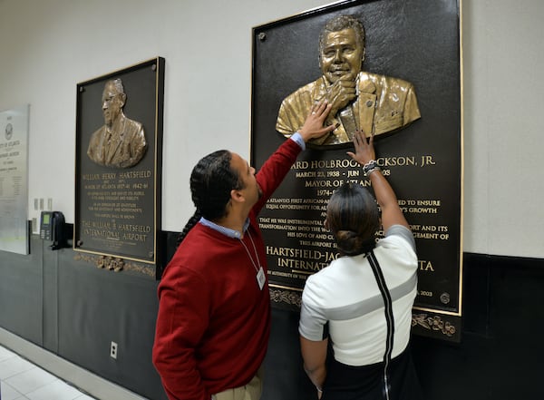 October 30, 2014. Atlanta: Maynard H. Jackson III, left, and Candace Byrd, chief of staff for Atlanta Mayor Kasim Reed touch the newly unveiled bronze relief plaque of Jackson's father, Maynard H. Jackson Jr. Local artist Fred Ajanogha unveiled the plaque of the former Atlanta Mayor during a ceremony Thursday October 30, 2014. The plaque is displayed at Hartsfield-Jackson International Airport, next to a plaque of Atlanta's longest serving mayor William B. Hartsfield. BRANT SANDERLIN / BSANDERLIN@AJC.COM