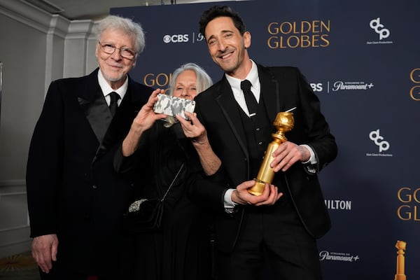 Elliot Brody, from left, Sylvia Plachy, and Adrien Brody, winner of the award for best performance by a male actor in a motion picture drama for "The Brutalist", pose in the press room during the 82nd Golden Globes on Sunday, Jan. 5, 2025, at the Beverly Hilton in Beverly Hills, Calif. (AP Photo/Chris Pizzello)