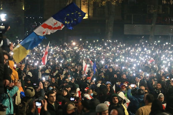 Demonstrators stand in front of police during a rally outside the parliament's building to protest the government's decision to suspend negotiations on joining the European Union for four years in Tbilisi, Georgia, on Saturday, Nov. 30, 2024. (AP Photo/Zurab Tsertsvadze)