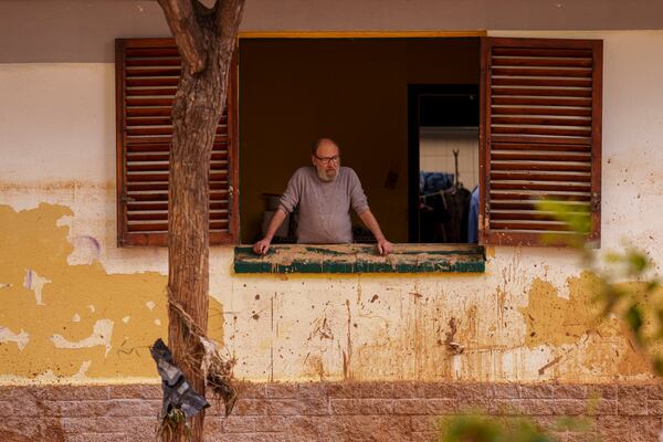 A man looks out of a window of his house in an a affected by floods in Alfafar, Spain, on Monday, Nov. 4, 2024. (AP Photo/Manu Fernandez)