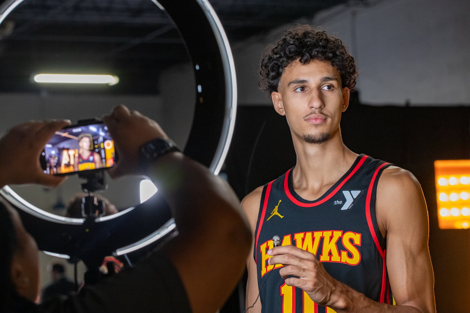 Waiting for the camera to be set, Hawks’ player Zaccharie Risacher #10, gets ready to be interviewed during media day on Monday, Sept 30, 2024 where media outlets including the Associated Press, Getty, NBA and many others gather to take photos, conduct interviews and gather footage.  (Jenni Girtman for The Atlanta Journal-Constitution)