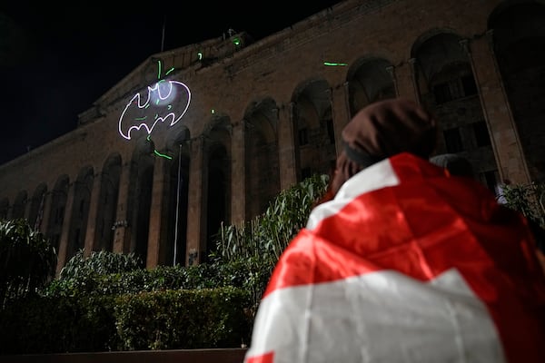 Demonstrators draw a bat with a laser on the facade of the parliament building during a rally to protests against the government's decision to suspend negotiations on joining the European Union, in Tbilisi, Georgia, Wednesday, Dec. 4, 2024. (AP Photo/Pavel Bednyakov)