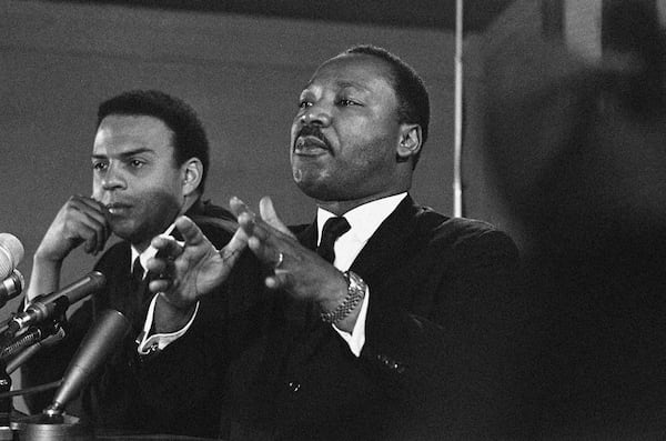 The Rev. Martin Luther King Jr. (right) speaks to an audience on Feb. 7, 1968, while promising a massive demonstration in the spring in Washington and hinting the crusade may be extended to the political party conventions in August. King, president of the Southern Christian Leadership Conference, said the demonstration in Washington will last for weeks and maybe for months. At left is the Rev. Andrew Young, executive vice president of the Southern Conference. There's a difference between an emotional outcry and a movement, said Young, who worked alongside King as a strategist during the Civil Rights Movement. (AP File)