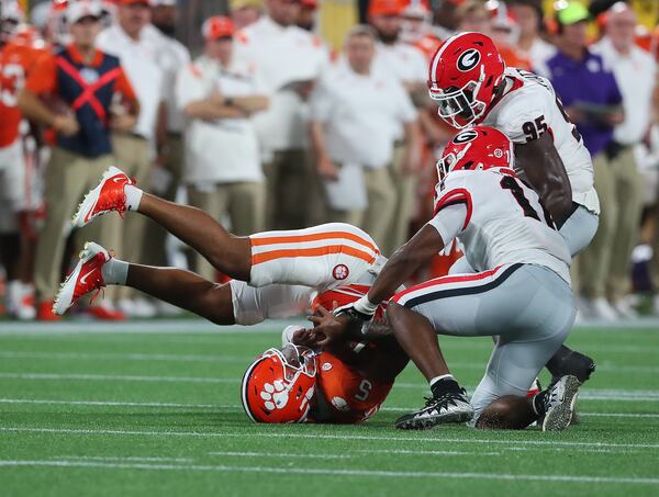 Georgia defenders inside linebacker Nakobe Dean and defensive lineman Devonte Wyatt sack Clemson quarterback D.J. Uiagalelei during the third quarter Saturday, Sept 4, 2021, in Charlotte, N.C. (Curtis Compton / Curtis.Compton@ajc.com)