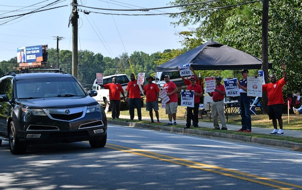 Striking AT&T workers hold signs outside AT&T facility on Brockett Road, Friday, Aug. 30, 2024, in Tucker. Some 17,000 AT&T workers in Atlanta and across the Southeast are on strike, having walked off their jobs on Aug. 16 amid an impasse in contract negotiations. (Hyosub Shin / AJC)