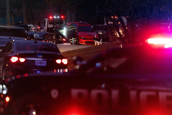 A tow truck driver loads a Dodge Charger outside a residence on Summer Chase Drive on Wednesday morning after an overnight shooting.