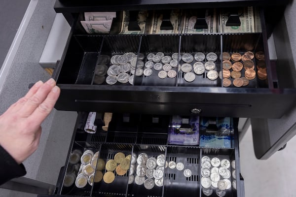 A cashier at the International Market in Point Roberts displays a till for U.S. Dollars and Canadian Dollars, Saturday, March 1, 2025, in Point Roberts, Wash. (AP Photo/Ryan Sun)