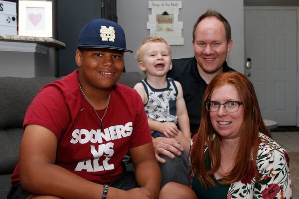 The Dunn family is pictured in their home  in Oklahoma City. From left are Izzy Simons, Cooper Dunn, Josh Dunn and Sarah Dunn. Sarah, who grew up in rural Kansas, has learned much about race since she and her husband, Josh, took custody of Izzy six years ago. 