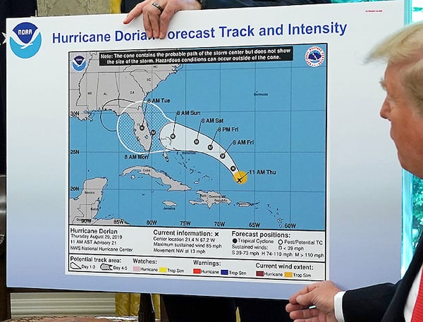 President Donald Trump references a map while talking to reporters about Hurricane Dorian in the Oval Office on September 4, 2019. The map proved controversial because it showed an early forecast track from August 29 and appears to have been altered by a black marker to extend the hurricane's range to include Alabama.