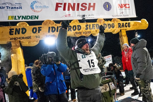 Jessie Holmes celebrates after winning the Iditarod Trail Sled Dog Race early Friday morning, March 14, 2025 in Nome. (Loren Holme/Anchorage Daily News via AP)