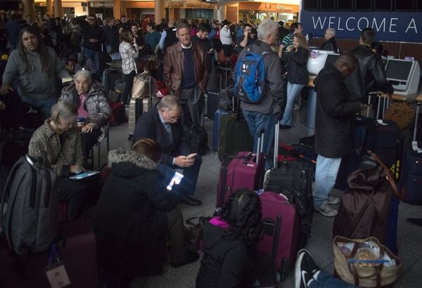 Passengers wait in a dark terminal at Hartsfield-Jackson International Airport on Sunday, Dec. 17, 2017. A power outage was reported at about 1 p.m. and several hours late the airport was still withou power. Inbound flights were put on hold and international flights were being diverted to other airports. (Photo: Steve Schaefer/The Atlanta Journal-Constitution)