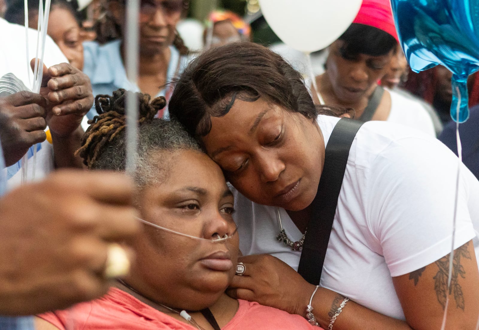 Arnitra Hollman, right, embraces Santeesh Crews, left, during a vigil and balloon release for Johnny Hollman on Tuesday, August 15, 2023, at Mary Shy Scott Park in Atlanta. Hollman died after he became unresponsive during an encounter with Atlanta police. (Michael Blackshire/Michael.blackshire@ajc.com)