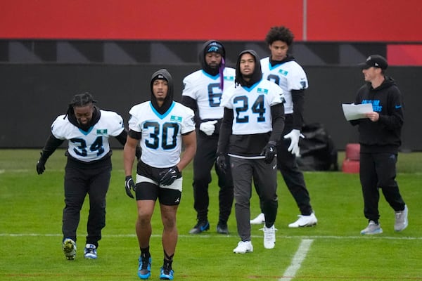 Carolina Panthers running back Chuba Hubbard (30) and Carolina Panthers running back Jonathon Brooks (24) warm up with team mates for a practice session in Munich, Germany, Friday, Nov. 8, 2024. The Carolina Panthers are set to play the New York Giants in an NFL game at the Allianz Arena in Munich on Sunday Nov. 10. (AP Photo/Matthias Schrader)