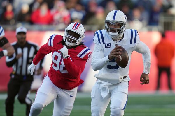 Indianapolis Colts quarterback Anthony Richardson (5) carries the ball against New England Patriots defensive tackle Jeremiah Pharms Jr. (98) during the second half of an NFL football game, Sunday, Dec. 1, 2024, in Foxborough, Mass. (AP Photo/Charles Krupa)