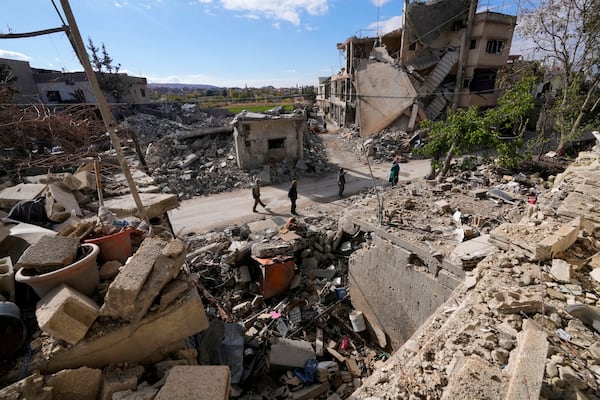 Residents check their destroyed neighborhood in Baalbek, eastern Lebanon, Thursday, Nov. 28, 2024. (AP Photo/Hassan Ammar)