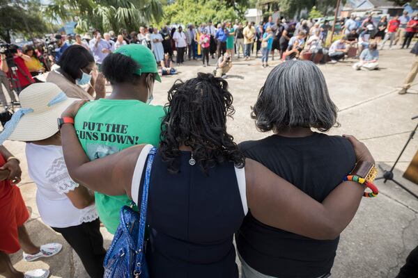 BRUNSWICK, GA - AUGUST, 9, 2022: Friends and supporters of Ahmaud Arbery bow their heads in prayer during an event dedicating a downtown street to the 25-year-old Black man who was fatally shot during an afternoon jog two years ago. (AJC Photo/Stephen B. Morton)