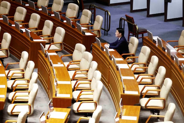 Lawmaker Ahn Chul-soo sits alone, the only People Power Party lawmaker who remains in the voting chamber during the plenary session for the impeachment vote of South Korean President Yoon Suk Yeol is set to take place at the National Assembly in Seoul, South Korea, Saturday, Dec. 7, 2024. (Jeon Heon-kyun/Pool Photo via AP)