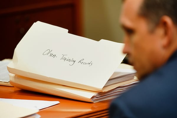 A folder titled "Olsen Training Records" is seen on the prosecution's desk behind prosecuting attorney Lance Cross during day five of the Robert Olsen murder trial at the DeKalb County Courthouse on October 3, 2019 in Decatur. Olsen is charged with murdering war veteran Anthony Hill. (Elijah Nouvelage for The Atlanta Journal-Constitution)