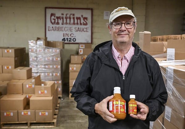 Roland Neel poses with bottles of Mrs. Griffin’s BBQ Sauce. Neel bought the company about 15 years ago and has carried on the legacy of Macon’s storied sauce ever since. (Photo Courtesy of Jason Vorhees / The Macon Melody)