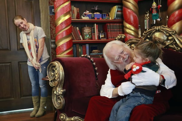 Debbie McGaw watches as her son, Noah, 2, reluctantly visits with Santa at North Point Mall in Alpharetta. Consumers are increasingly buying Christmas gifts online, but Santa visits help draw parents of young kids to malls across the nation. BOB ANDRES /BANDRES@AJC.COM