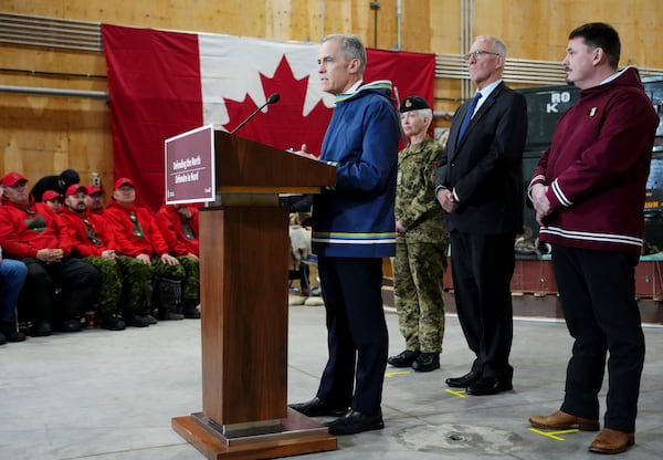 Canada Prime Minister Mark Carney, left to right, makes an announcement as Chief of Defence Staff Gen. Jennie Carignan, Defence Minister Bill Blair and Nunavut Premier P.J. Akeeagok look on at a Canadian Armed Forces forward-operating location in Iqaluit, Nunavut, on Tuesday, March 18, 2025. (Sean Kilpatrick/The Canadian Press via AP)