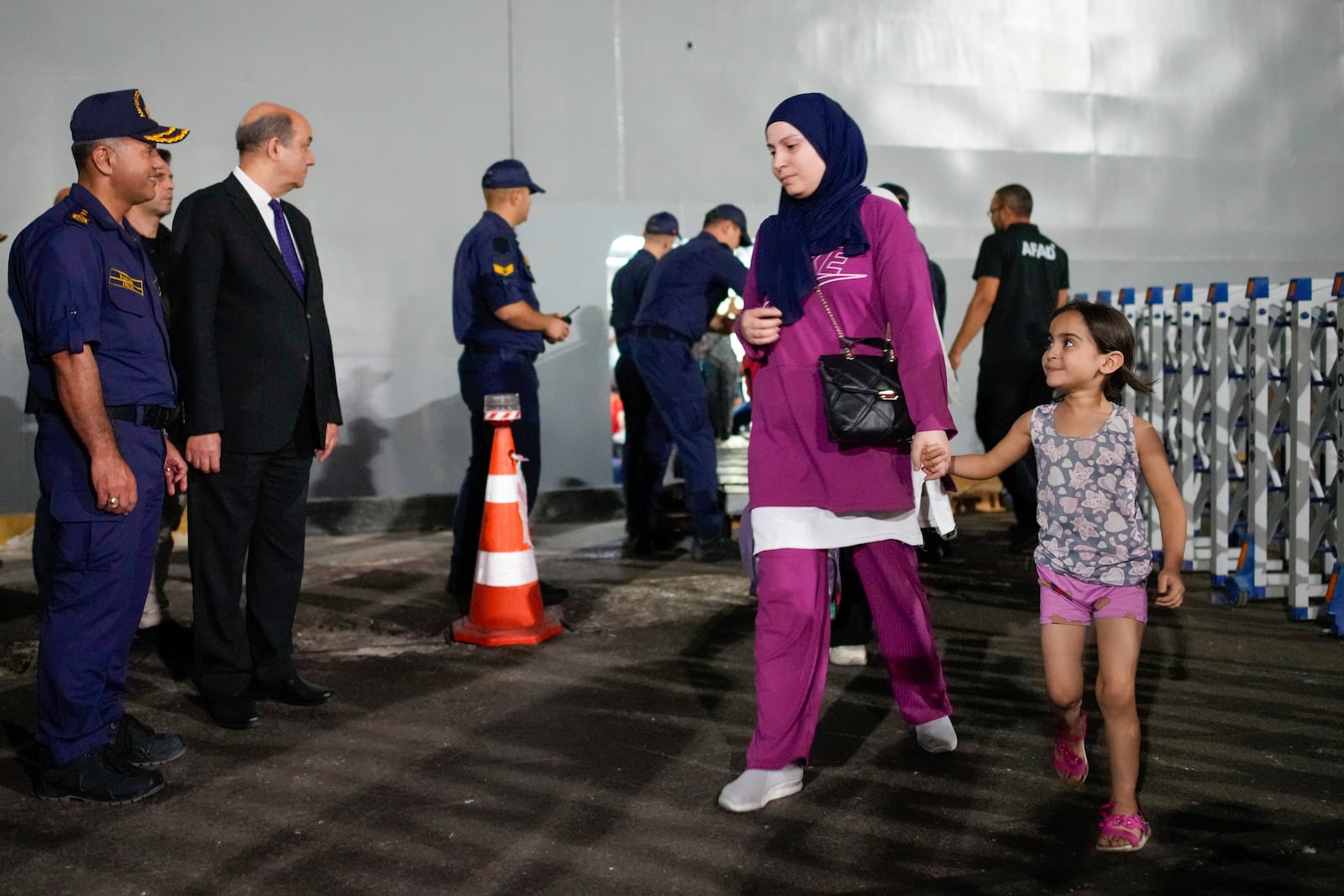 People, mostly Turkish nationals, disembark from Turkish TCG Sancaktar military ship after being evacuated from Lebanon's capital Beirut to Turkey, in Mersin port, southern Turkey, early Friday, Oct. 11, 2024. (AP Photo/Emrah Gurel)