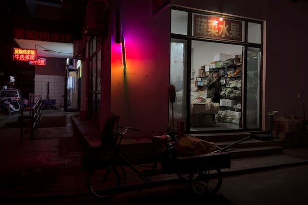 A man buys vegetable at a store near a residential area in Beijing on Saturday, March 8, 2025. (AP Photo/Andy Wong)