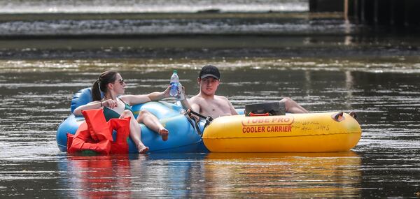 Rachel Leinmiller (left) and Justin Cochran (right) toast one another as they begin their trek down the Chattahoochee River from Powers Island on Wednesday, Sept. 2, 2020. They finally got to cross off the river float off their summer bucket list after working 6-days a week and dodging rainy days. (John Spink / John.Spink@ajc.com)


