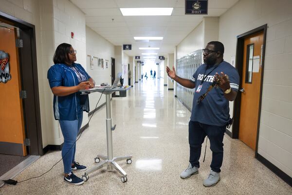 Principal Rodney Jordan, right, talks with Assistant Principal Porsha Denson in front of her office in the hallway at South Gwinnett High School, Friday, March 29, 2024, in Snellville. Jordan has implemented campus monitors, assistant principals and other staff members to be position in all of the zones of the high school hallways. (Jason Getz / AJC)