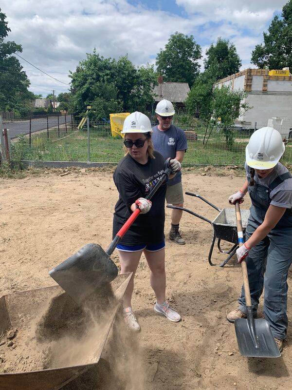 Irene Devine, a 21-year-old college student, helps load wheelbarrows of dirt to address a drainage issue. For Devine, this journey — and the opportunity to help others, whether at home or abroad — were particularly meaningful. When she was 15, Devine and her mother moved into their own Habitat for Humanity home in De Soto, Mo. “I was extremely overwhelmed by the Habitat volunteers who helped build that home for us,” Devine said. “They became our second family.” MARK A. WALIGORE / MARK.WALIGORE@AJC.COM