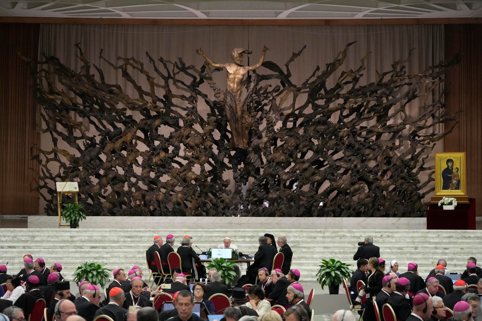 Pope Francis, background center, attends the works of the second session of the 16th General Assembly of the Synod of Bishops in the Paul VI hall, at the Vatican, Saturday, Oct. 26, 2024. (AP Photo/Gregorio Borgia)