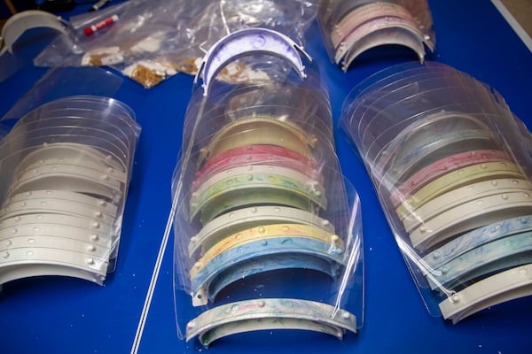 At Paralink's headquarters, in the basement of Michael Giusto's house in an Alpharetta subdivision, are stacks of face shields, ready to be shipped to hospitals. ALYSSA POINTER / ALYSSA.POINTER@AJC.COM