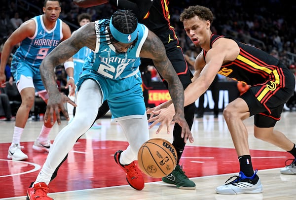 Hawks guard Dyson Daniels (right) fights for a loose ball during a recent game against the Hornets.