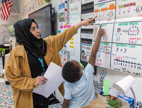 Shaikila Amiaq, a recent Afghan refugee who is studying to become a teacher, helps a student at the International Community School in Clarkston. During his first term as president, Donald Trump cut deeply into the country’s annual refugee admissions cap, bringing it to a historic low of 18,000. President Joe Biden brought it back up to 125,000. Now, Trump appears poised to suspend the program altogether. Phil Skinner for The Atlanta Journal-Constitution file