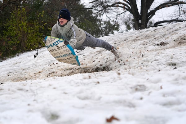 Luke Choat slides on a small snow covered hill Thursday, Jan. 9, 2025, in Richardson, Texas. (AP Photo/LM Otero)