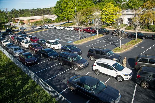 An abundance of cars with families in need of groceries line up in the parking lot at the Lawrenceville Cooperative Ministry in Lawrenceville on April 15, 2020. (ALYSSA POINTER / ALYSSA.POINTER@AJC.COM)