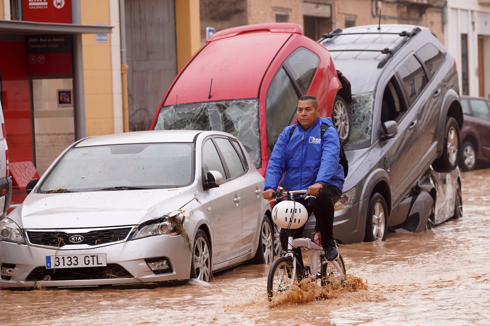 A man rides a bicycle through flooded streets in Valencia, Spain, Wednesday, Oct. 30, 2024. (AP Photo/Alberto Saiz)