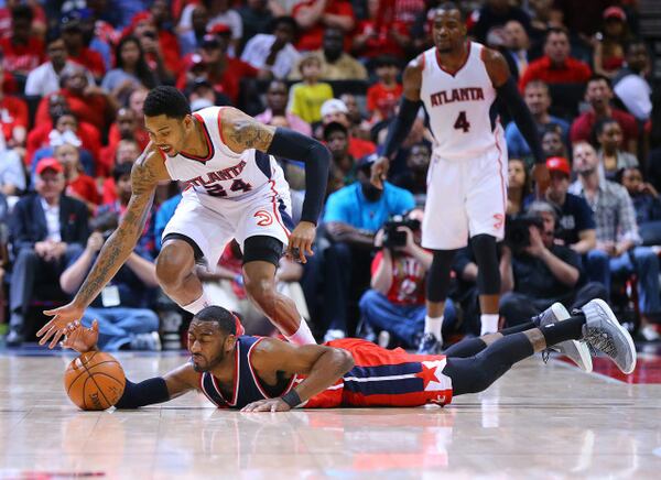 050315 ATLANTA: Wizards John Wall hits the hardwood as Hawks Kent Bazemore defends on the play in game 1 of the Eastern Conference Semifinals on Sunday, May 3, 2015, in Atlanta. Curtis Compton / ccompton@ajc.com