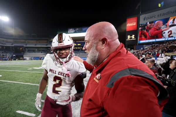 Mill Creek defensive back Caleb Downs celebrates with coach Josh Lovelady during the closing minutes of their 70-35 win against Carrollton in the GHSA Class 7A finals, at Center Parc Stadium, Saturday, Dec. 10, 2022, in Atlanta. (Jason Getz / Jason.Getz@ajc.com)