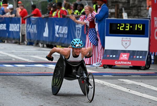 Susannah Scaroni crosses the finish line winning the women's wheelchair division during the 2023 Atlanta Journal-Constitution Peachtree Road Race, Tuesday, July 4, 2023, in Atlanta. (Hyosub Shin / Hyosub.Shin@ajc.com)