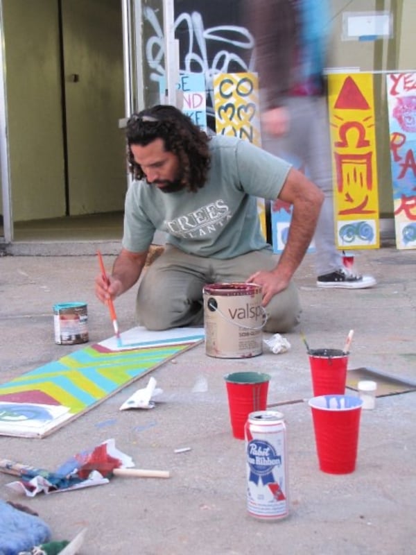 Angel Poventud is shown at a 2010 sign painting event after the artist community activist lobbied Beltline officials to mark the trails with handmade signs. Volunteers made 240 signs up and down the Beltline. Soon, that was followed by more guerrilla-style art and murals.