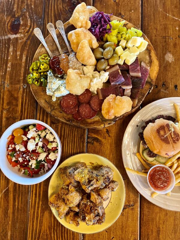 With its Bosnian influences, Best End Brewing’s food differs from that of most Atlanta breweries. Shown here (clockwise from the top) are the charcuterie board, Balkan burger, cauliflower nuggets and shopska salad. (Wendell Brock for The Atlanta Journal-Constitution)