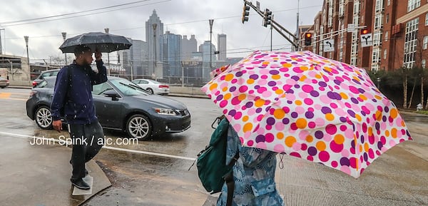 Pedestrians needed umbrellas early Tuesday as they made their way across North Avenue near the Downtown Connector.