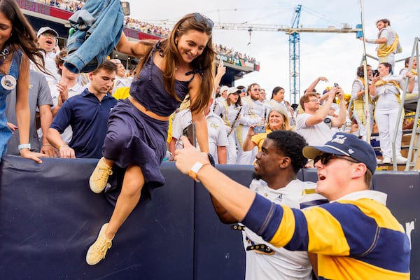 Georgia Tech wide receiver Avery Boyd (9) helps fans over the wall after the second half of an NCAA football game against Miami, Saturday, Nov. 9, 2024, in Atlanta. (AP Photo/Jason Allen)