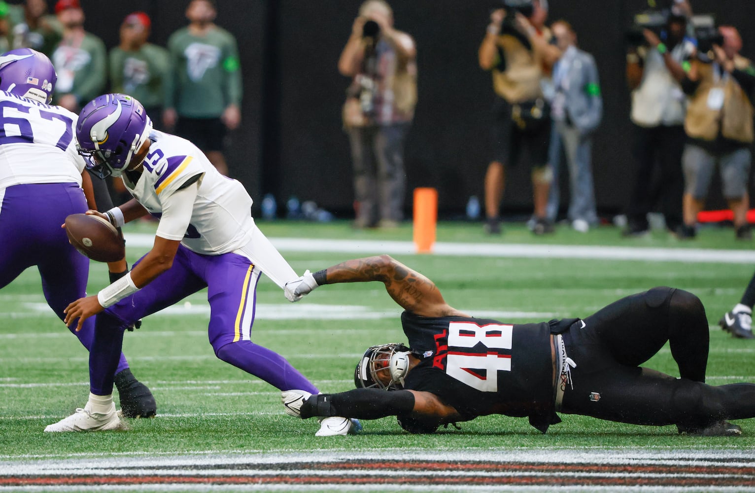 Minnesota Vikings quarterback Joshua Dobbs evades Atlanta Falcons linebacker Bud Dupree (48) and scrambles for a first down during the second half an NFL football game in Atlanta on Sunday, Nov. 5, 2023. The Vikings won 31 - 28. (Bob Andres for the Atlanta Journal Constitution)