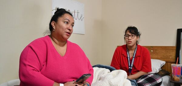 Maria Fernandez and her daughter in the motel room that has been their home for years. They hope for a move to an apartment in April -- with help from a pilot program.